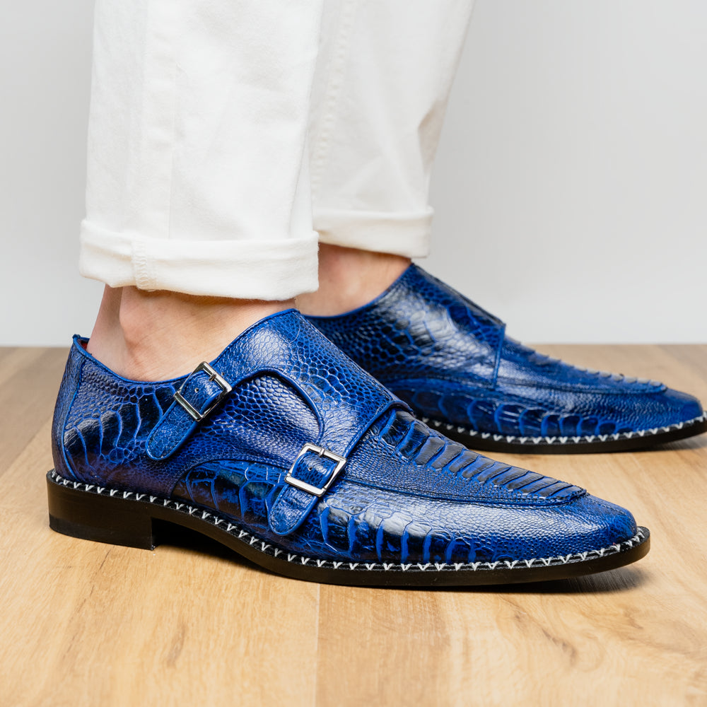 The Marco Di Milano Napoli Electric Blue exotic leather double monk strap shoes are shown: one upright and one on its side displaying the sole, set against a white background.