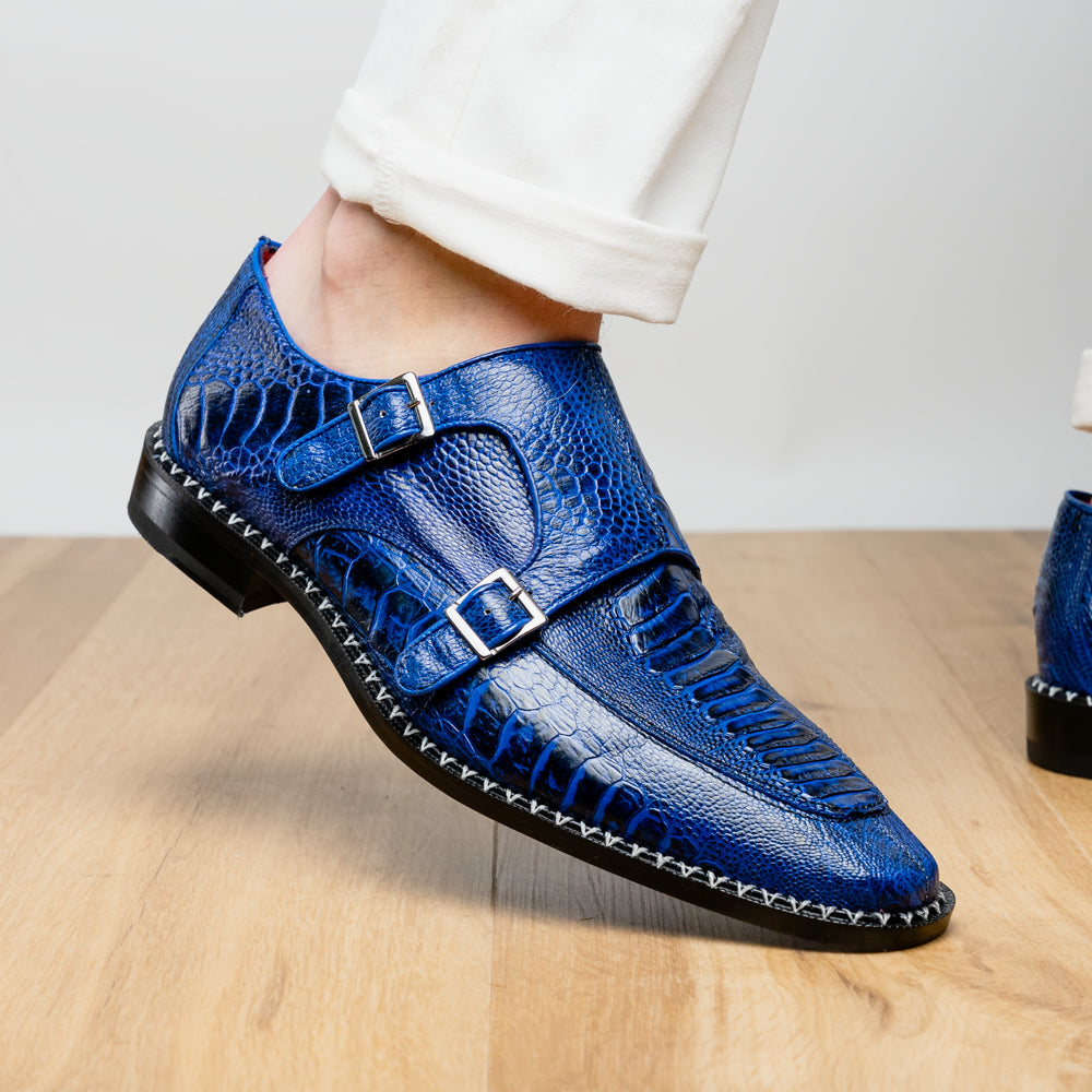 The Marco Di Milano Napoli Electric Blue exotic leather double monk strap shoes are shown: one upright and one on its side displaying the sole, set against a white background.