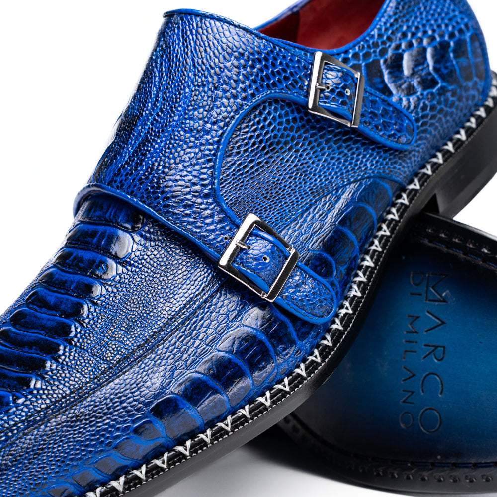 The Marco Di Milano Napoli Electric Blue exotic leather double monk strap shoes are shown: one upright and one on its side displaying the sole, set against a white background.