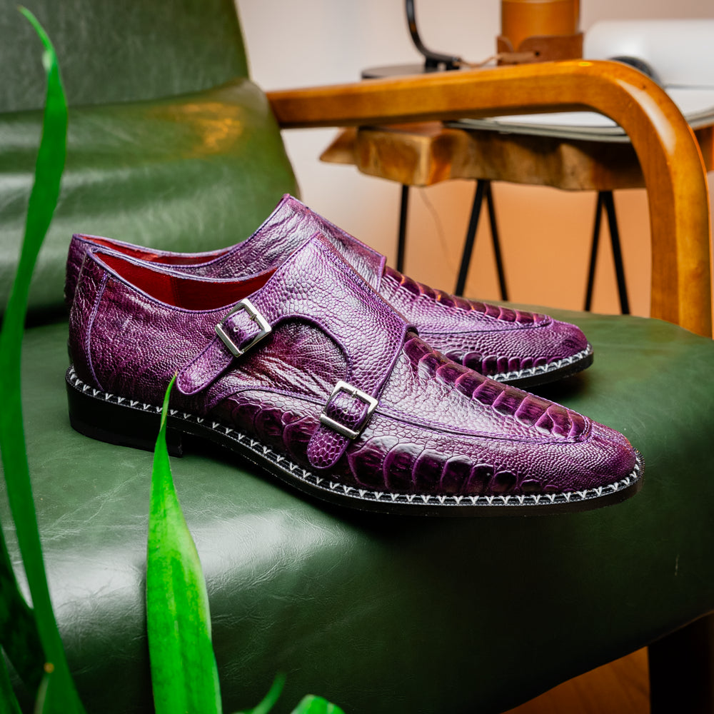 The Marco Di Milano Napoli Purple dress shoes feature genuine ostrich leather, a double monk strap, and textured detailing, with one shoe shown on its side to highlight the sole.