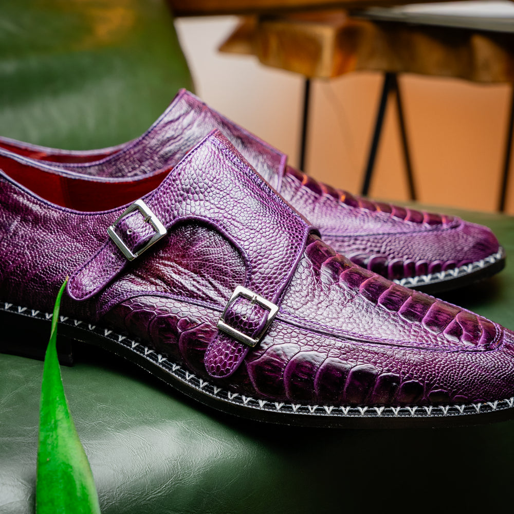 The Marco Di Milano Napoli Purple dress shoes feature genuine ostrich leather, a double monk strap, and textured detailing, with one shoe shown on its side to highlight the sole.