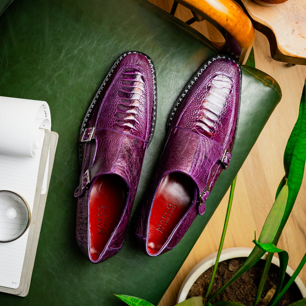 The Marco Di Milano Napoli Purple dress shoes feature genuine ostrich leather, a double monk strap, and textured detailing, with one shoe shown on its side to highlight the sole.