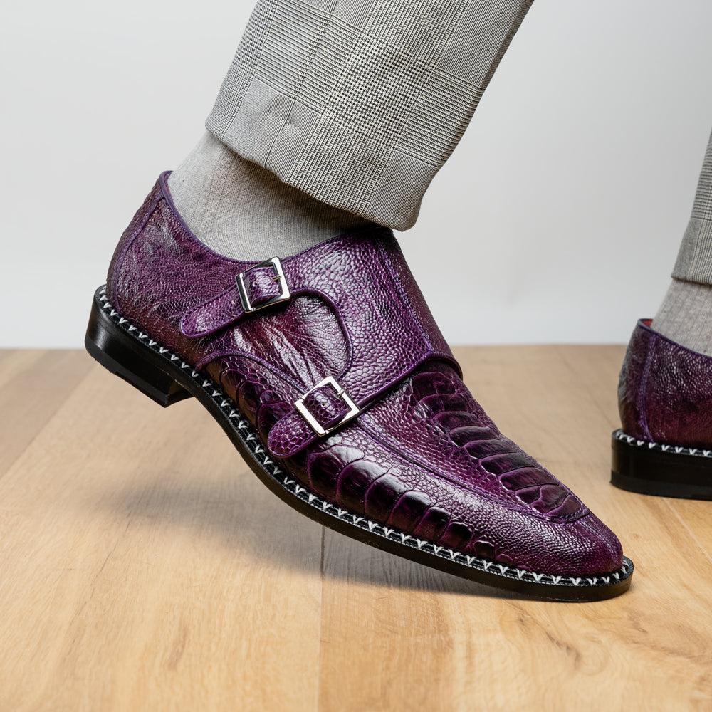 The Marco Di Milano Napoli Purple dress shoes feature genuine ostrich leather, a double monk strap, and textured detailing, with one shoe shown on its side to highlight the sole.