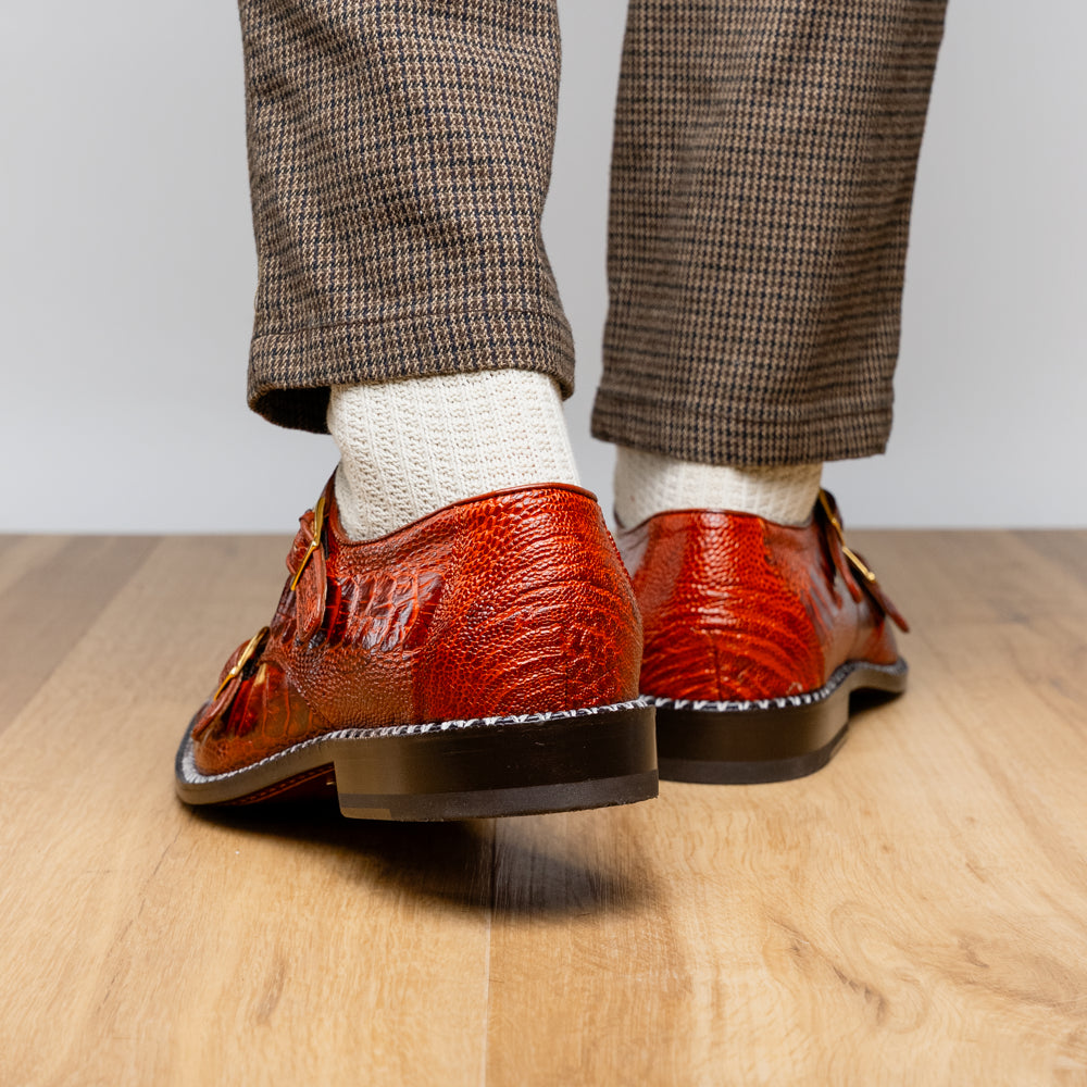 A pair of Marco Di Milano Napoli Rustic Cognac double monk strap dress shoes in genuine ostrich leg leather, with one shoe upright and the other on its side to show the sole.