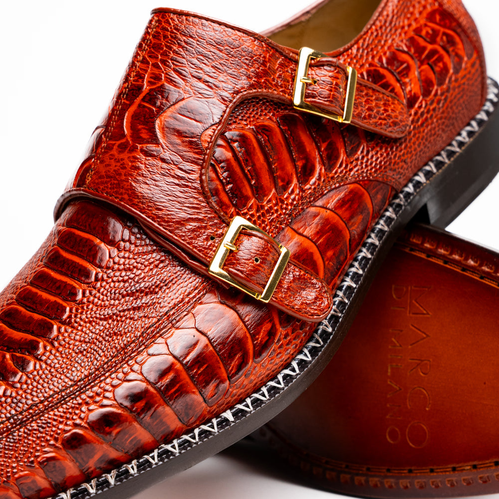 A pair of Marco Di Milano Napoli Rustic Cognac double monk strap dress shoes in genuine ostrich leg leather, with one shoe upright and the other on its side to show the sole.