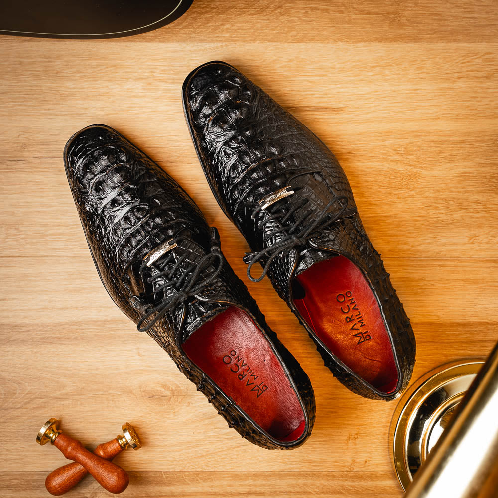 The Nilo Black by Marco Di Milano is a pair of luxury men's shoes made from polished black Nile crocodile skin with red inner lining and brown leather soles embossed with the brand name.