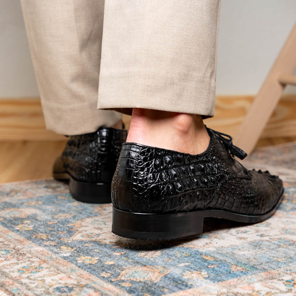 The Nilo Black by Marco Di Milano is a pair of luxury men's shoes made from polished black Nile crocodile skin with red inner lining and brown leather soles embossed with the brand name.