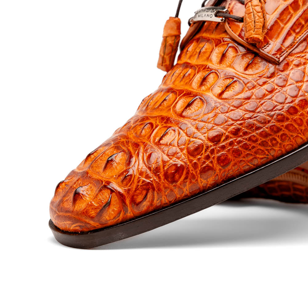 The Nilo Brandy by Marco Di Milano is a pair of orange luxury shoes made from Premium Nile Crocodile Skin with black laces—one shoe upright, the other flat to highlight its exquisite sole.