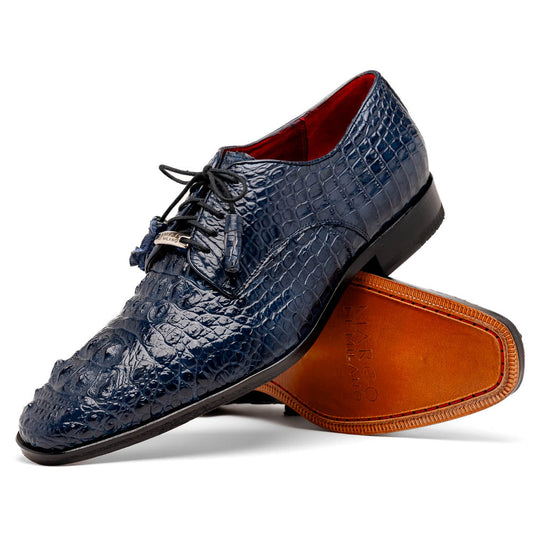 The Nilo Navy by Marco Di Milano features dark blue luxury footwear crafted from premium Nile crocodile skin with black laces and brown leather soles, displayed with one shoe propped on the other.