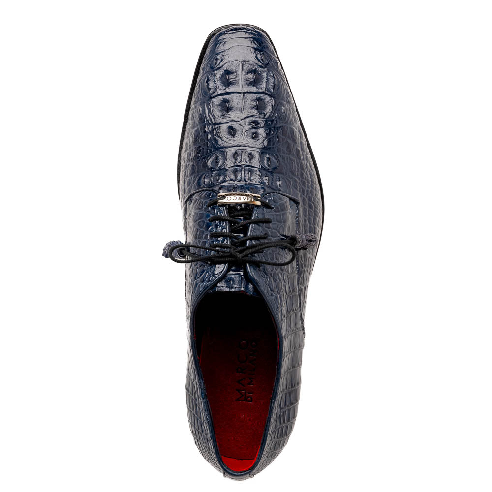 The Nilo Navy by Marco Di Milano features dark blue luxury footwear crafted from premium Nile crocodile skin with black laces and brown leather soles, displayed with one shoe propped on the other.