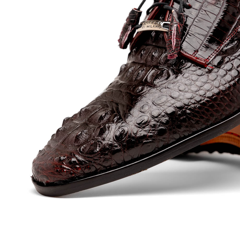The Marco Di Milano Nilo Wine shoes are luxury dress footwear crafted from dark brown, textured Italian leather, featuring red interior lining and tan leather soles, with one shoe stylishly propped on the other.
