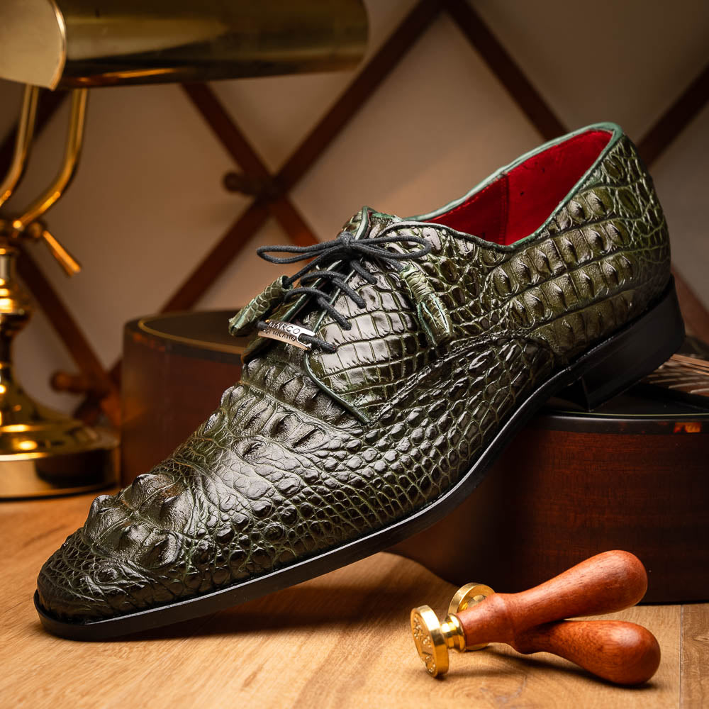 The Nilo Forest Green by Marco Di Milano is a luxury pair crafted from premium Nile crocodile skin in green, with black laces—one shoe upright, the other showing a branded brown leather sole.