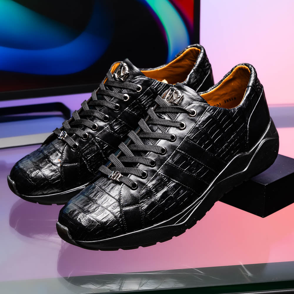 The Nino Black by Marco Di Milano: genuine black caiman crocodile sneakers with black laces and a textured rubber sole, one standing and one leaning, highlighting luxury footwear with a striking hand painted finish.