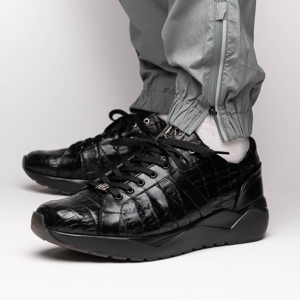 The Nino Black by Marco Di Milano: genuine black caiman crocodile sneakers with black laces and a textured rubber sole, one standing and one leaning, highlighting luxury footwear with a striking hand painted finish.