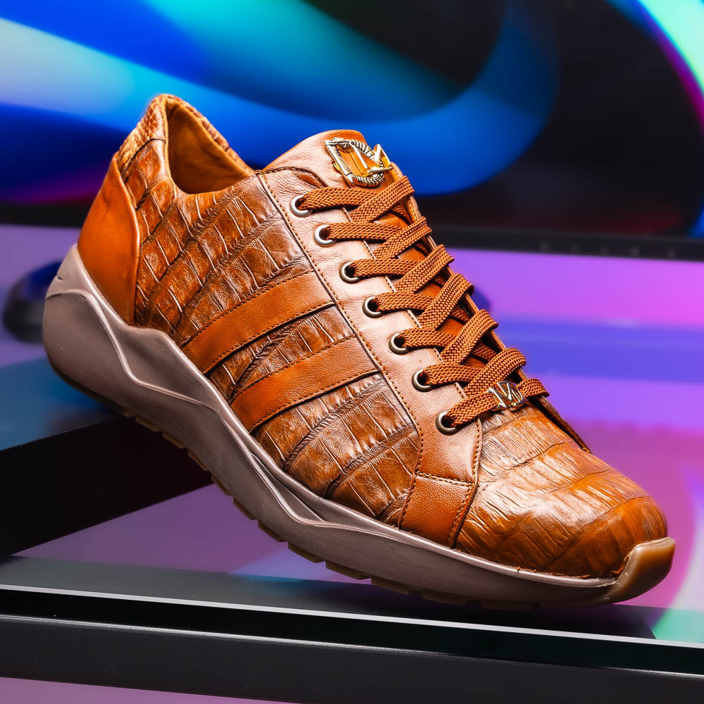The Marco Di Milano Nino Bay Apache: luxurious brown genuine caiman crocodile sneakers, hand-painted with dark brown laces and grooved rubber soles—one stands upright while the other is shown lying on its side.