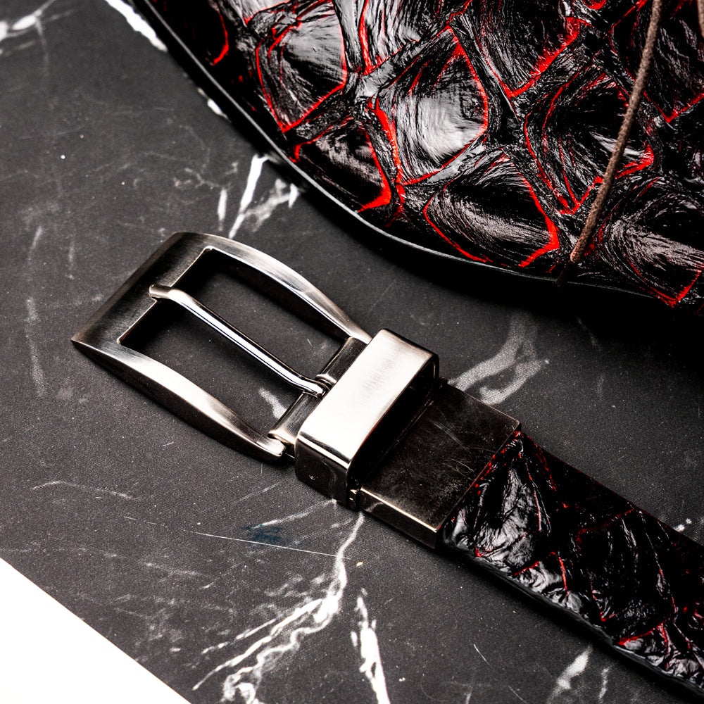 The Olivieri Belt Blackcherry by Marco Di Milano is a luxury men’s accessory crafted from black leather with red textured patterns, rolled up and showcased with a silver rectangular buckle on a white background—making it an exquisite exotic leather belt choice for any sophisticated wardrobe.
