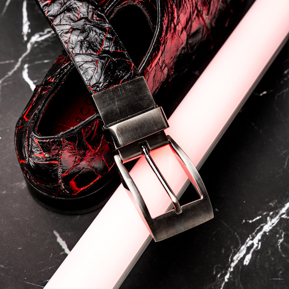 The Olivieri Belt Blackcherry by Marco Di Milano is a luxury men’s accessory crafted from black leather with red textured patterns, rolled up and showcased with a silver rectangular buckle on a white background—making it an exquisite exotic leather belt choice for any sophisticated wardrobe.