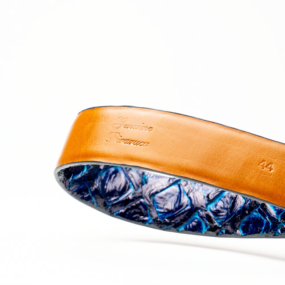 The Olivieri Belt Royal Blue by Marco Di Milano, featuring blue textured genuine pirarucu leather and a silver buckle, is coiled elegantly against a white background—an exquisite example of an exotic belt designed for the discerning gentleman.