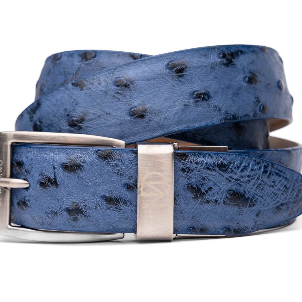The Domenico Belt Antique Navy by Marco Di Milano features a blue textured ostrich leather, a silver buckle, subtle spotted pattern, and engraved brand logos on both the buckle and belt loop.