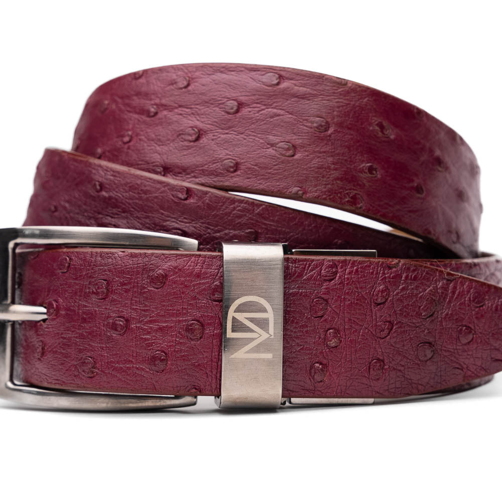 The Domenico Belt Wine by Marco Di Milano is crafted from maroon leather with an exotic ostrich texture and a silver buckle engraved with "Marco Di Milano" and "MD", featuring exquisite hand-painted finishes to complement luxury footwear.