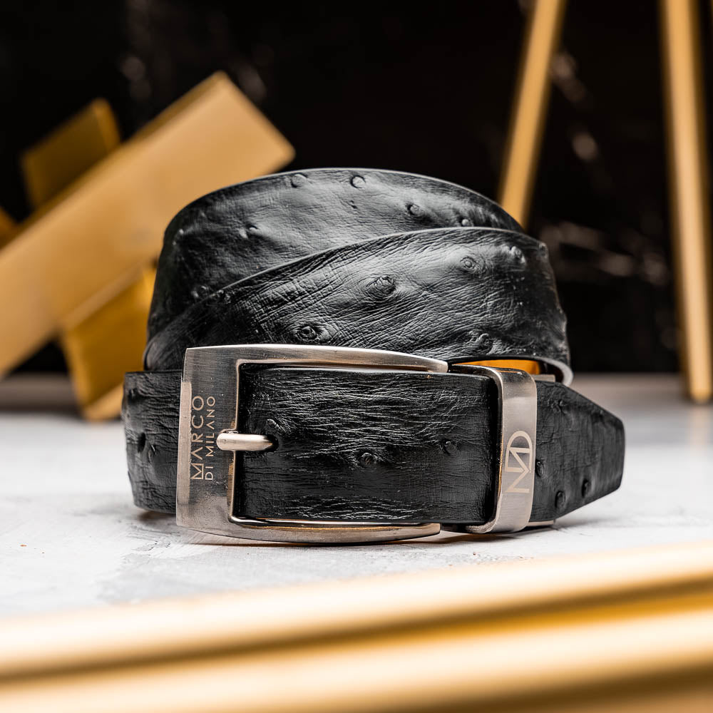 The Domenico Belt Black by Marco Di Milano features black ostrich leather, a silver buckle, and the "MARCO DI MILANO" logo on the metal loop—a sophisticated accessory from the luxury brand Marco Di Milano.