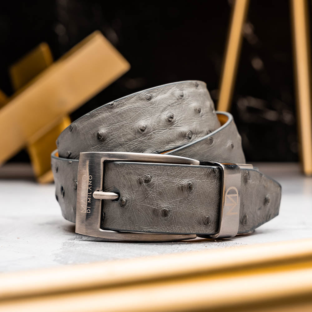 The Domenico Belt Gray by Marco Di Milano is crafted from grey ostrich leather and features a silver buckle engraved with "Marco Di Milano" and the "MD" logo, reflecting the brand's luxurious craftsmanship. Shown coiled on a white background.
