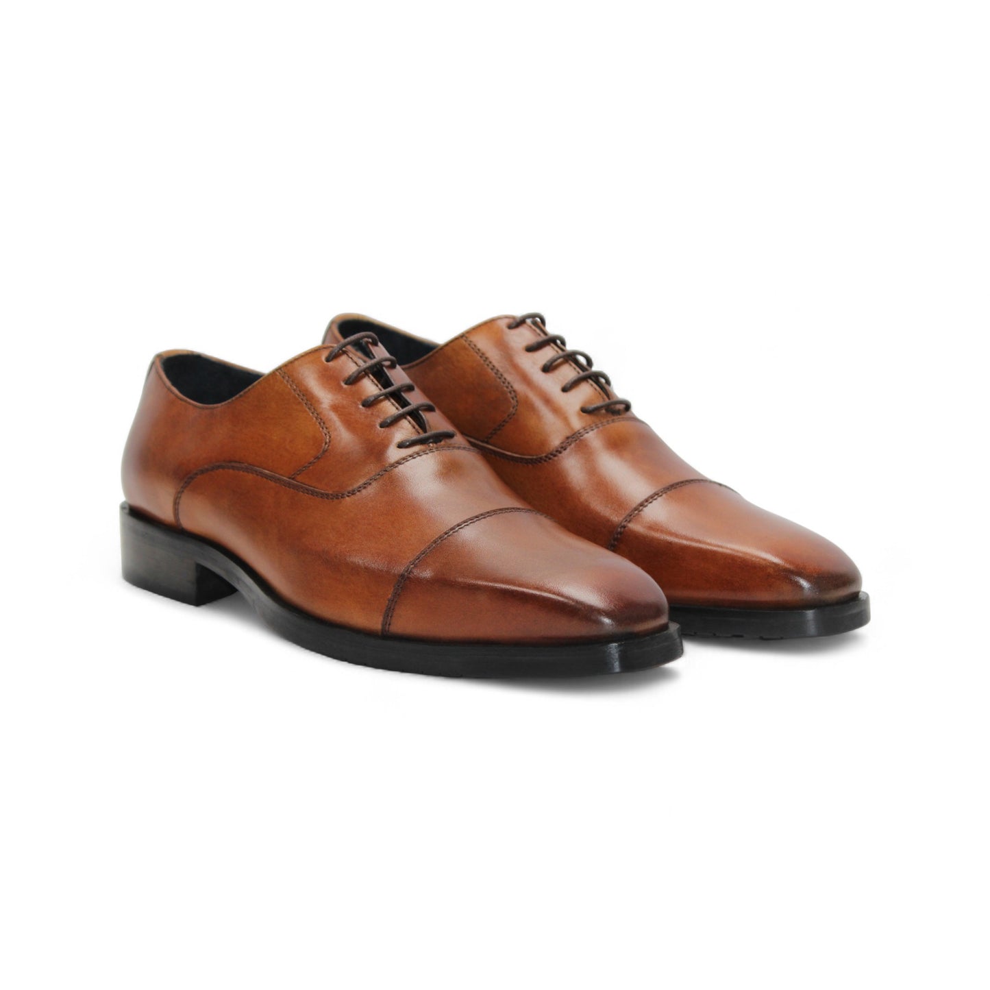 The Firmani Owen Cognac by Firmani is a brown genuine leather oxford dress shoe with a black sole, shown in a side view on a plain white background—ideal for timeless style enthusiasts.