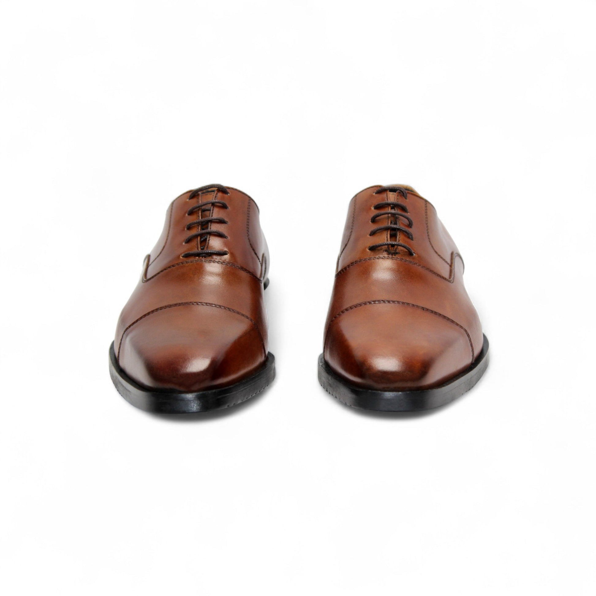 The Firmani Owen Cognac by Firmani is a brown genuine leather oxford dress shoe with a black sole, shown in a side view on a plain white background—ideal for timeless style enthusiasts.