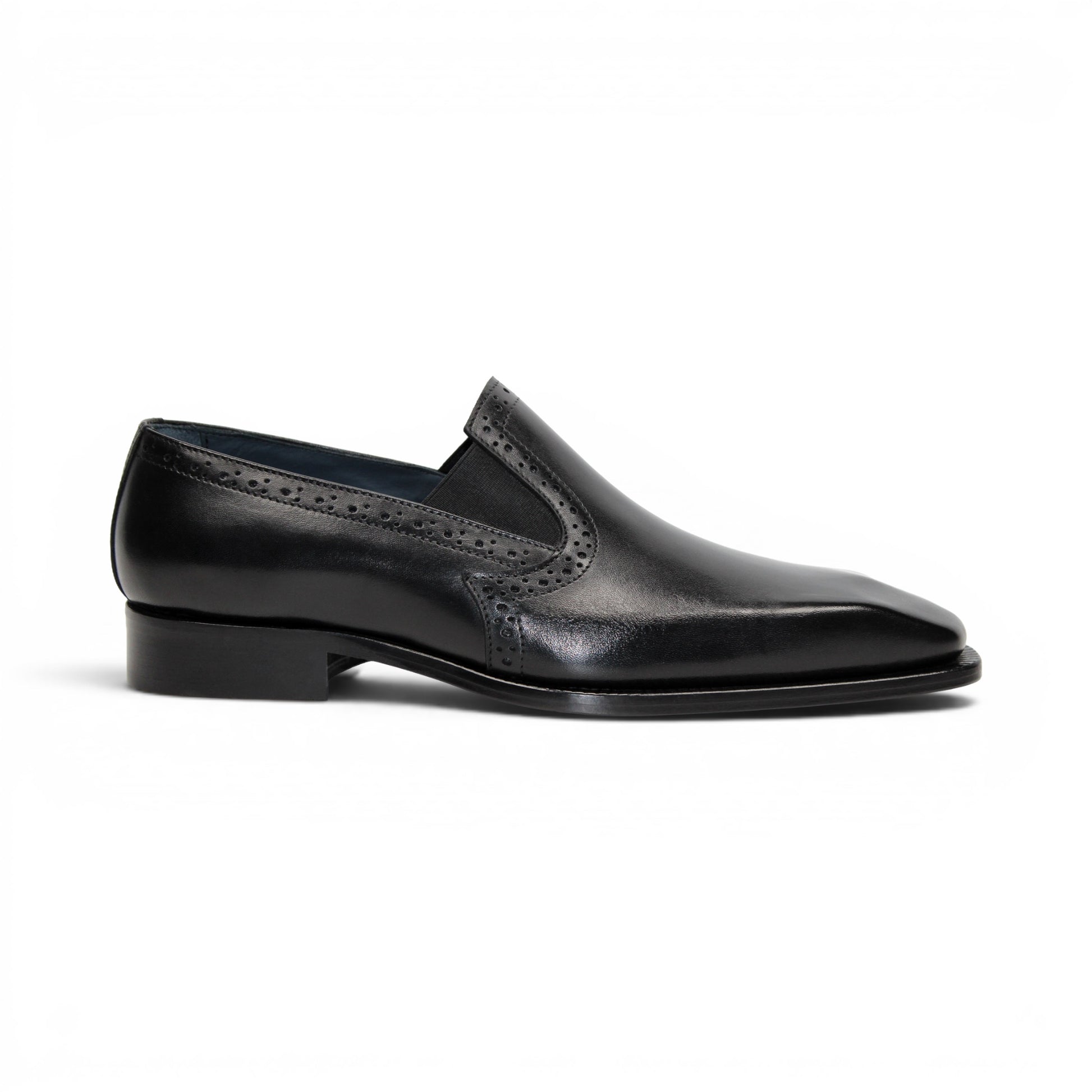 The Duca Di Matiste Duca Paliano Black is an Italian-made slip-on dress shoe in premium black calf leather, featuring a low heel and decorative perforations, shown in profile for timeless style.