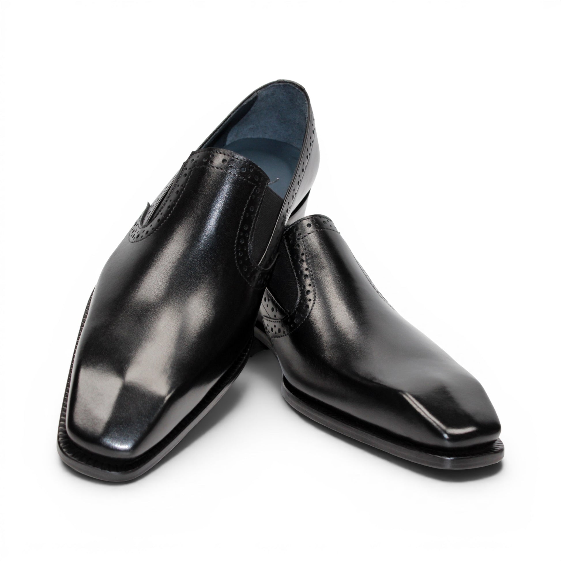 The Duca Di Matiste Duca Paliano Black is an Italian-made slip-on dress shoe in premium black calf leather, featuring a low heel and decorative perforations, shown in profile for timeless style.