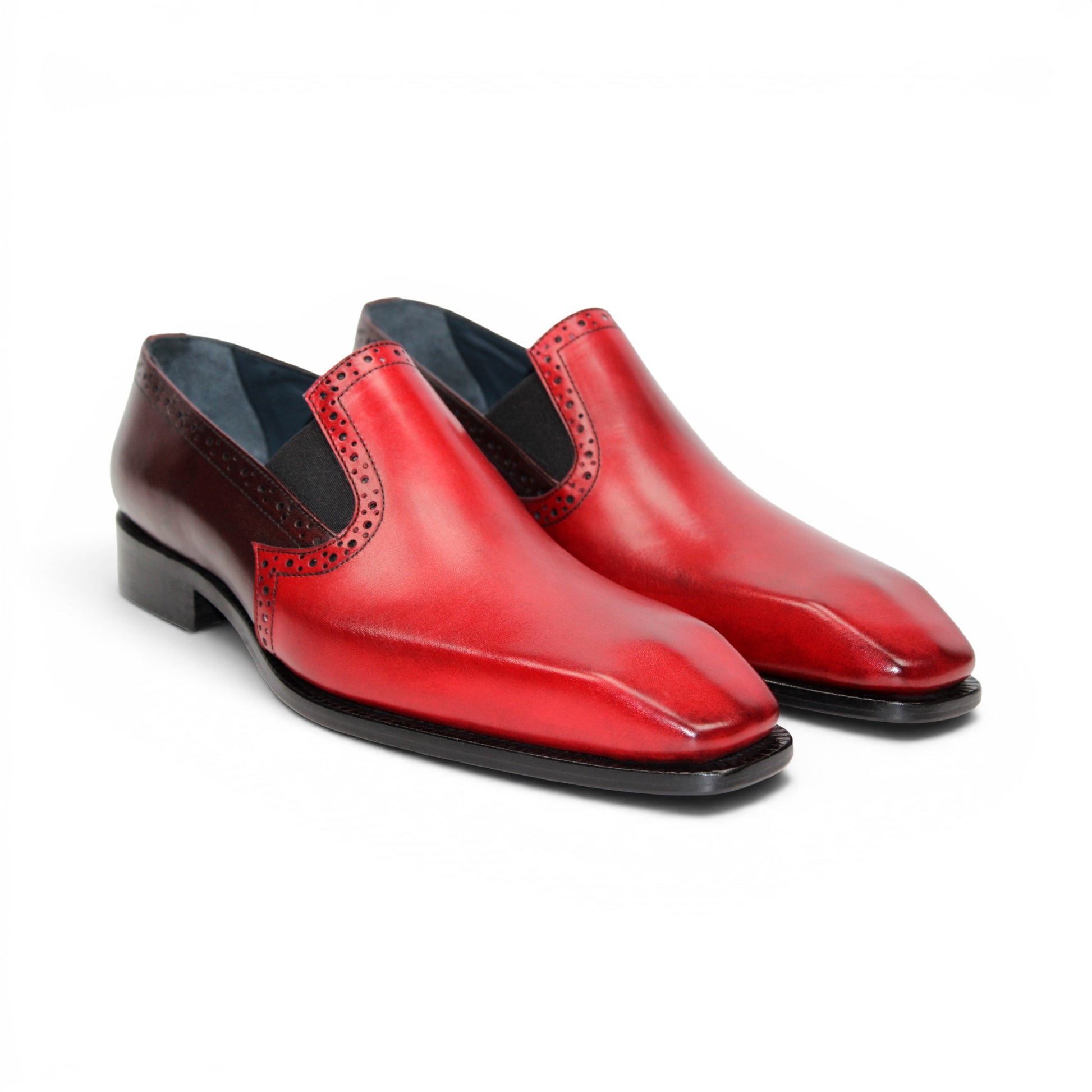 The Duca Di Matiste Duca Paliano Red/Burgundy is a men’s slip-on dress shoe in fine calf leather, featuring a red and dark brown upper with decorative perforations and a black low heel—Italian-made timeless style.