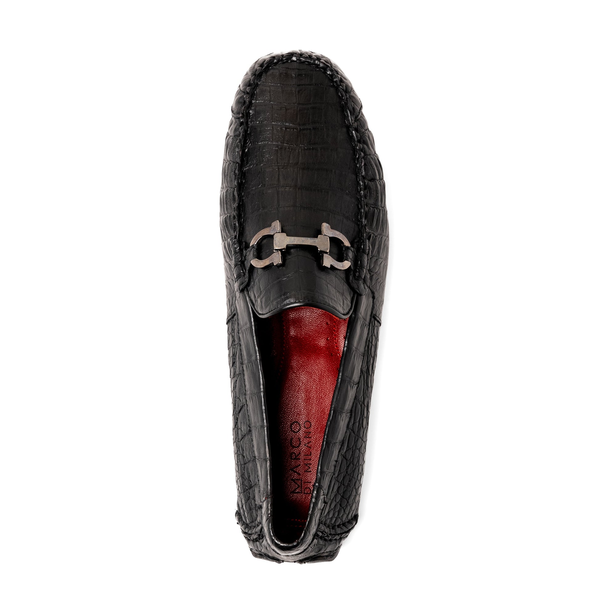 The Marco Di Milano Parma Black is a luxury caiman belly loafer featuring black crocodile-textured leather, metal buckle accents, and rubber soles, with one men’s driving shoe upright and the other leaning against it.