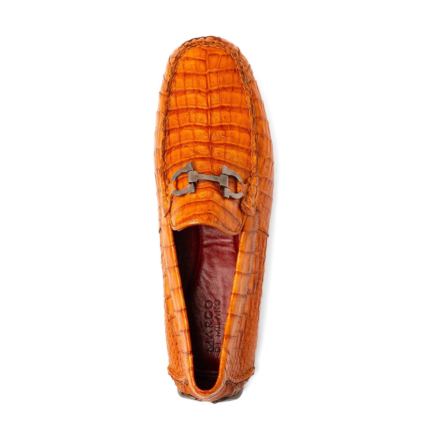 Marco Di Milano’s Parma Brandy loafers feature an orange crocodile pattern, black metal buckles, and hand-painted finishes—one shoe stands upright while the other lies on its side to reveal the detailed sole.
