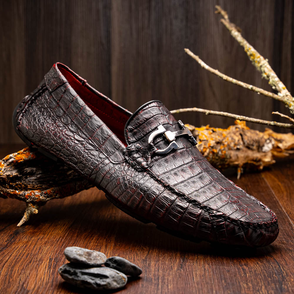 The Marco Di Milano Parma Blackcherry loafers feature genuine caiman leather with a crocodile pattern and metal buckle detail—luxury men's slip-ons shown upright and angled to display the sole, designed for effortless elegance.