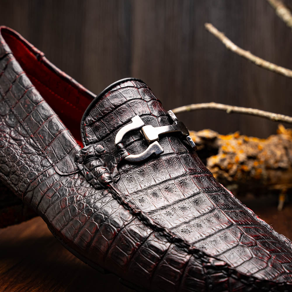 The Marco Di Milano Parma Blackcherry loafers feature genuine caiman leather with a crocodile pattern and metal buckle detail—luxury men's slip-ons shown upright and angled to display the sole, designed for effortless elegance.