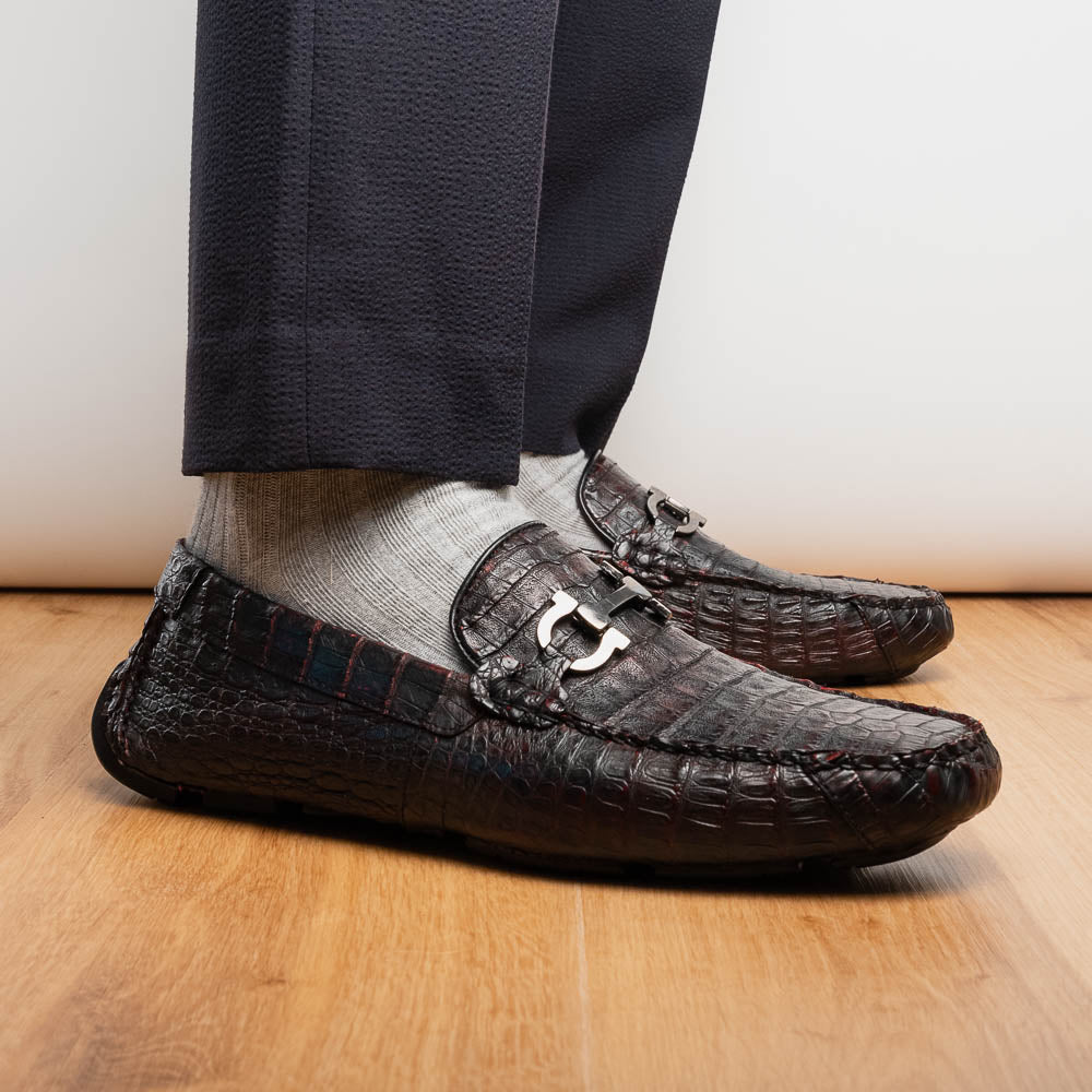 The Marco Di Milano Parma Blackcherry loafers feature genuine caiman leather with a crocodile pattern and metal buckle detail—luxury men's slip-ons shown upright and angled to display the sole, designed for effortless elegance.