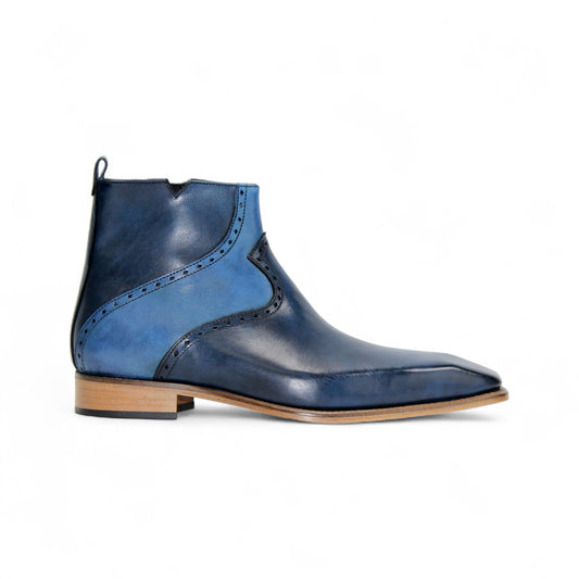 The Duca Pedaso Navy by Duca Di Matiste is a genuine leather ankle boot in blue, featuring black stitching, a side zipper, low wooden heel, and pointed toe, displayed in profile against a white background.