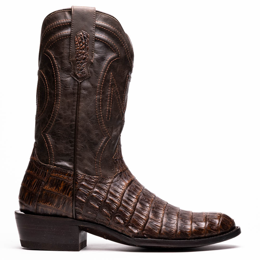 A pair of Marco Di Milano Phoenix Aged Brown men's boots, one upright and one showing the sole, crafted from genuine caiman belly skin with a crocodile texture and detailed stitching—ideal for any Western collection.