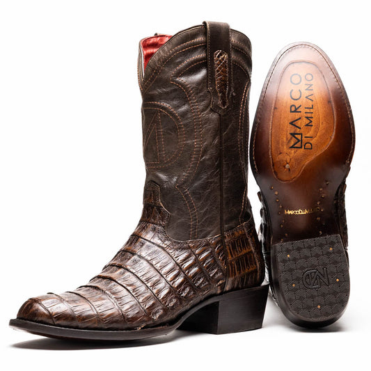 A pair of Marco Di Milano Phoenix Aged Brown men's boots, one upright and one showing the sole, crafted from genuine caiman belly skin with a crocodile texture and detailed stitching—ideal for any Western collection.