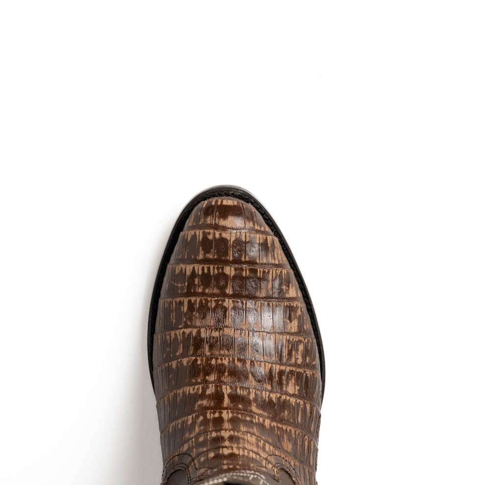 The Phoenix Stone Brown by Marco Di Milano are brown Western cowboy boots featuring crocodile-patterned textured leather, decorative stitching, and branded soles.
