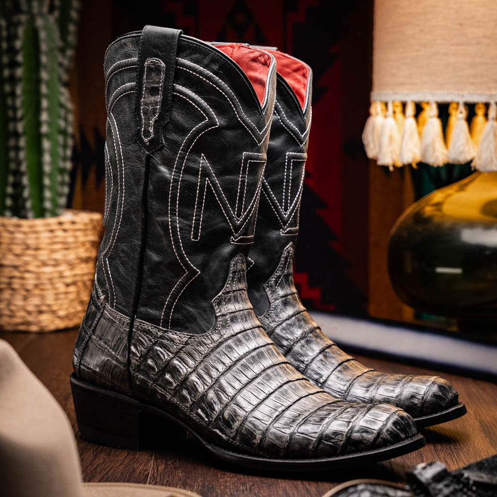 A pair of Phoenix Stone Gray cowboy boots by Marco Di Milano—one boot upright and the other displaying the branded sole.