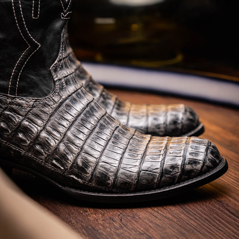 A pair of Phoenix Stone Gray cowboy boots by Marco Di Milano—one boot upright and the other displaying the branded sole.