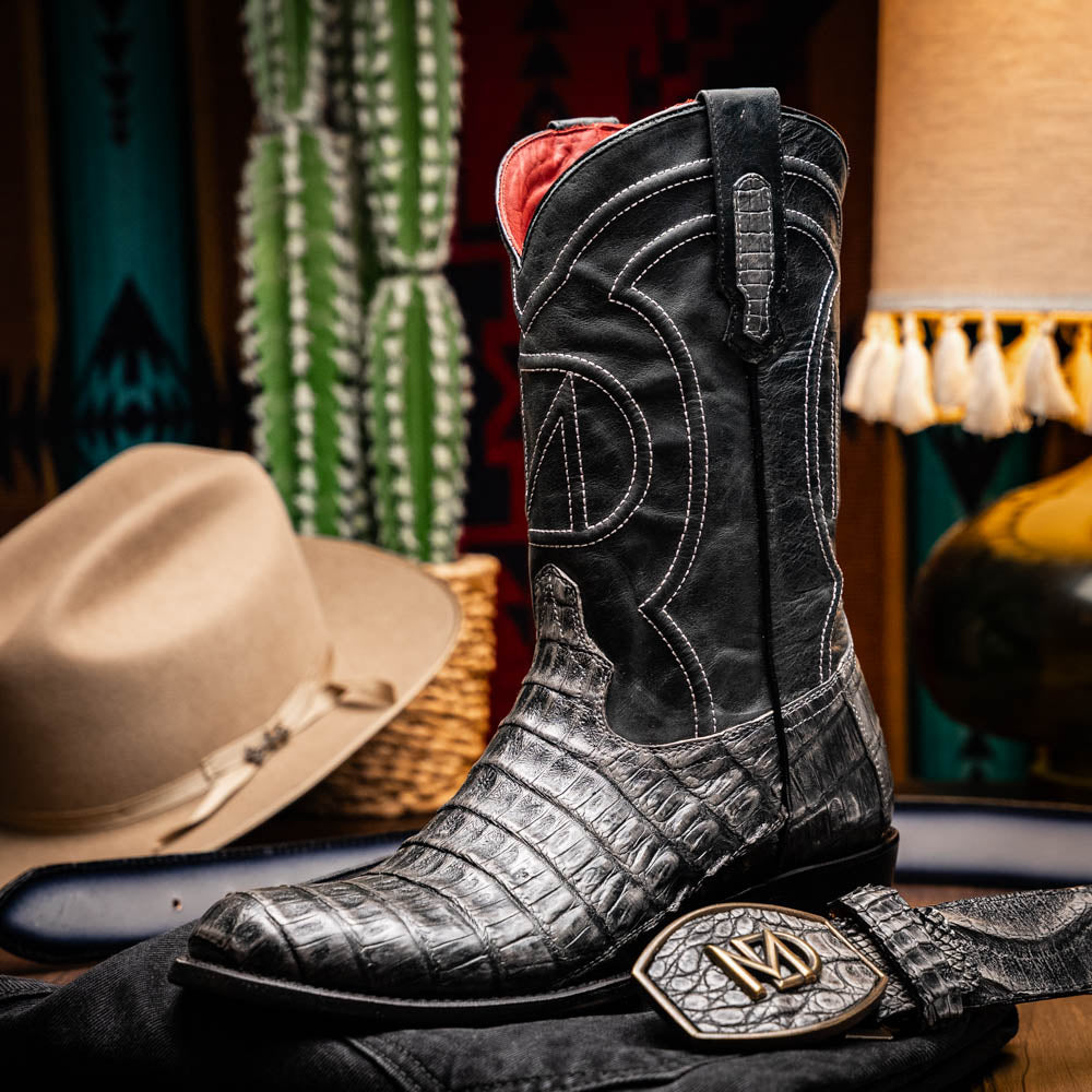 A pair of Phoenix Stone Gray cowboy boots by Marco Di Milano—one boot upright and the other displaying the branded sole.