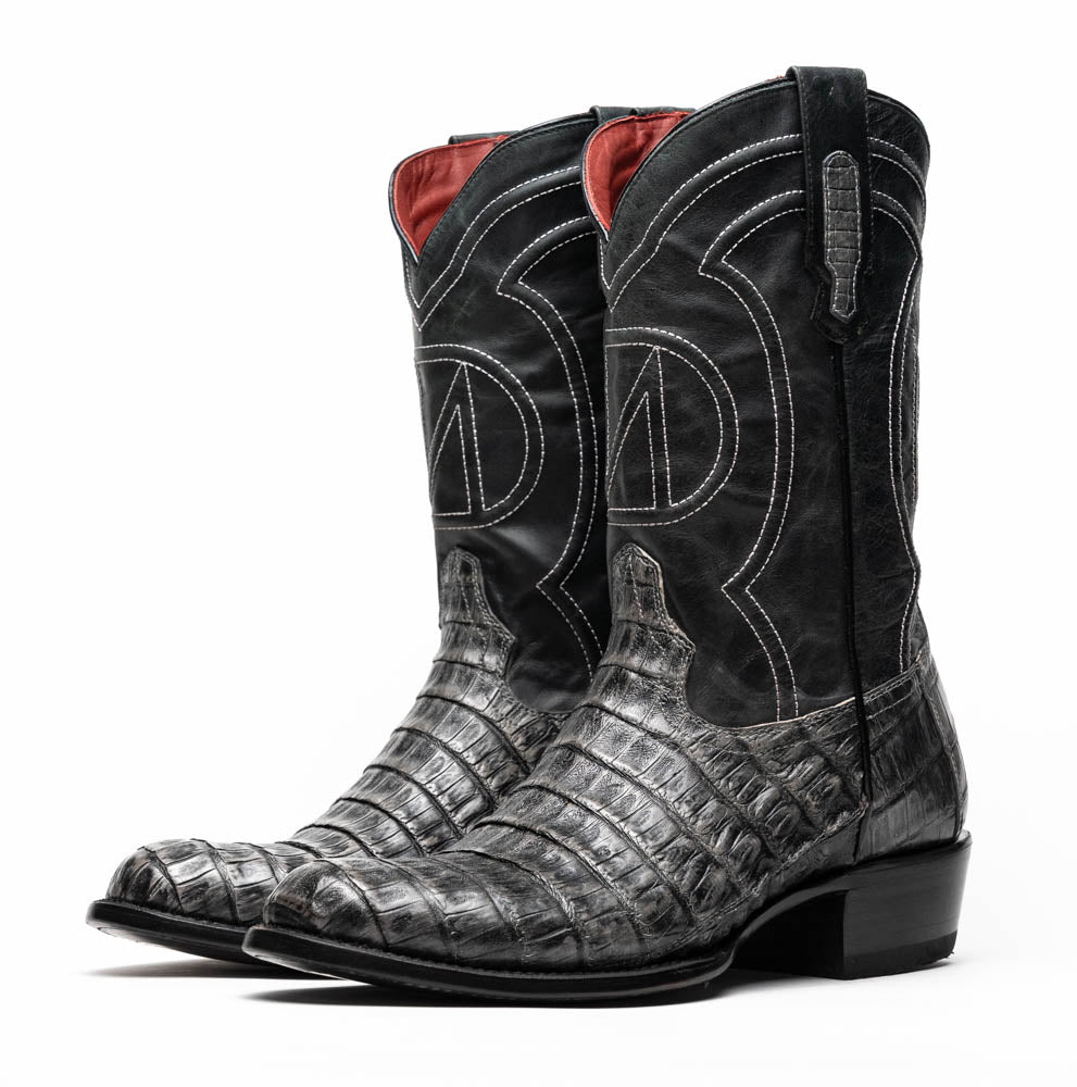 A pair of Phoenix Stone Gray cowboy boots by Marco Di Milano—one boot upright and the other displaying the branded sole.
