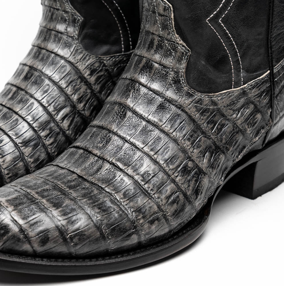 A pair of Phoenix Stone Gray cowboy boots by Marco Di Milano—one boot upright and the other displaying the branded sole.