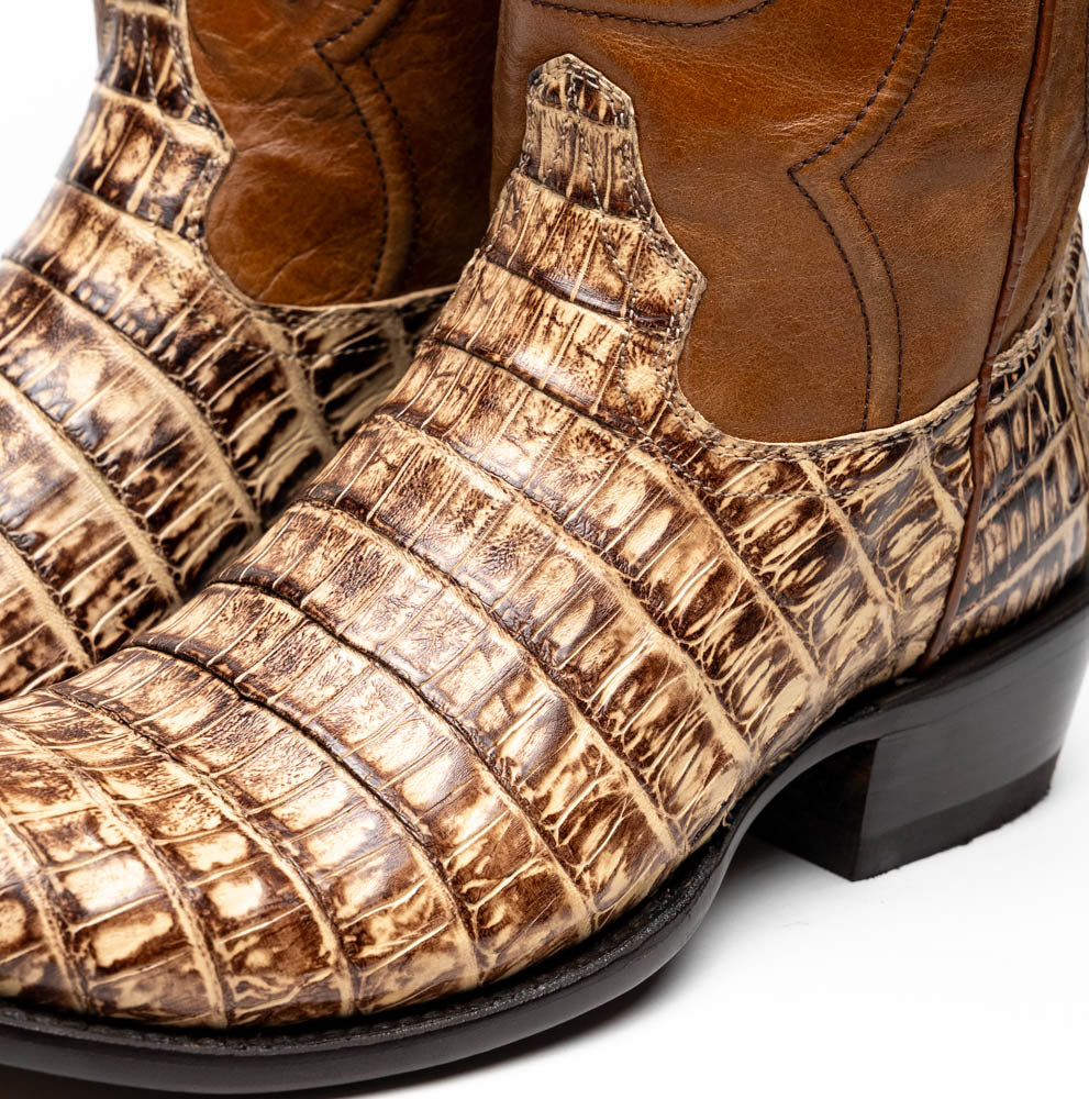 A pair of Phoenix Stone Orix brown Western cowboy boots by Marco Di Milano, featuring an alligator texture—one boot upright, the other displaying the sole with the brand logo.