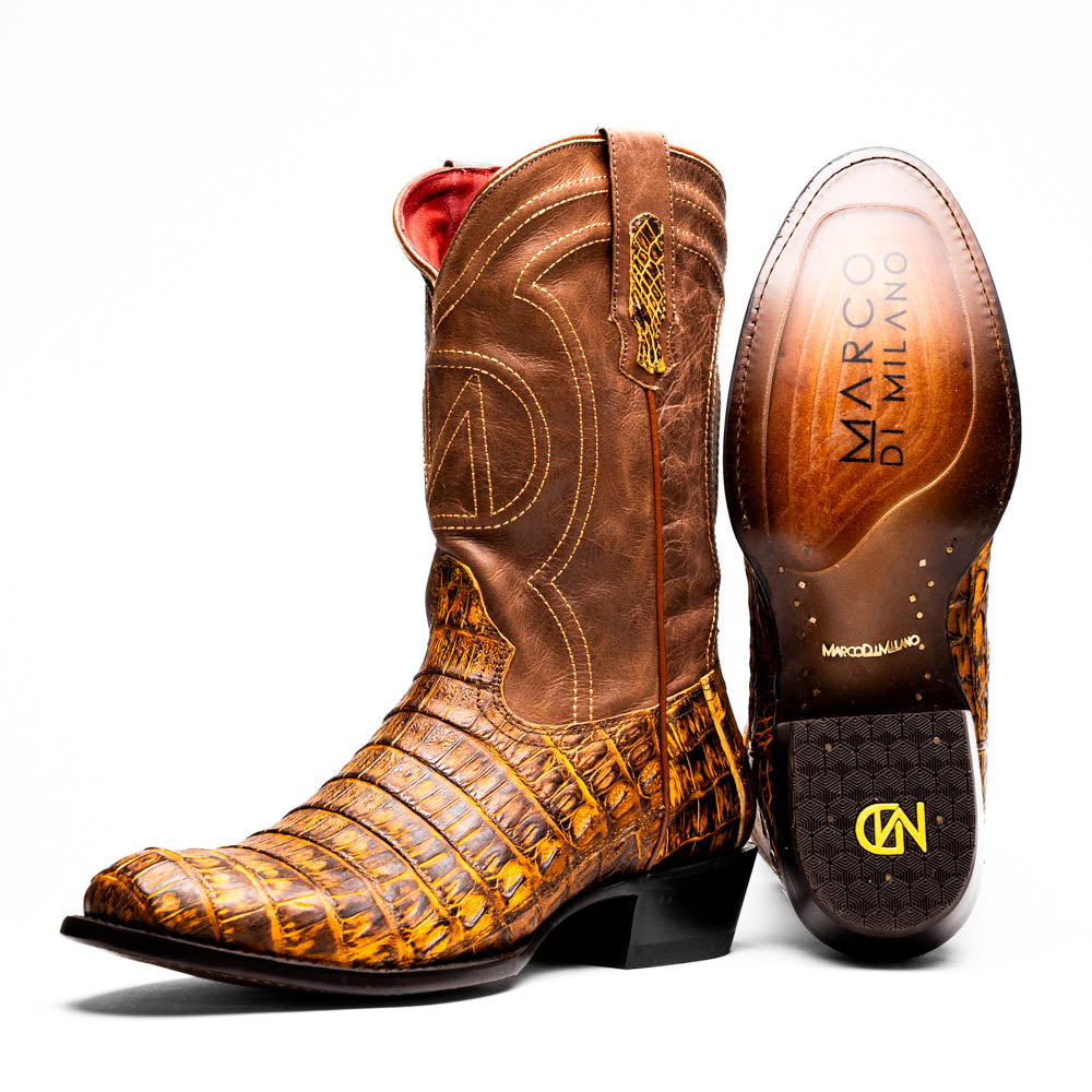 The Phoenix Mustard Brown by Marco Di Milano is a pair of Western boots in genuine caiman belly leather with a textured exotic finish and branded sole, shown against a white background.