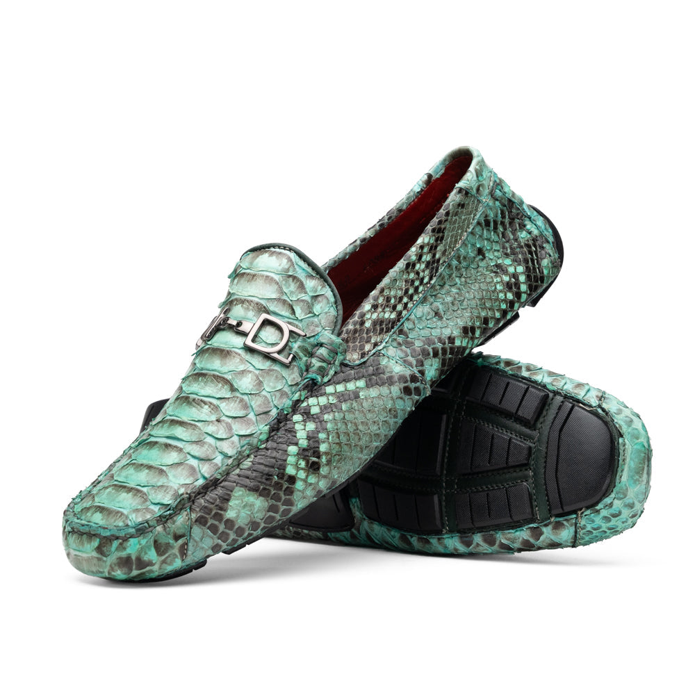 Introducing the Pia Aqua by Marco Di Milano—a pair of luxury men’s loafers handcrafted from striking green python skin. Featuring black rubber soles and silver buckle accents, one shoe is elegantly displayed on its side to highlight the distinctive design of this opulent driver shoe.