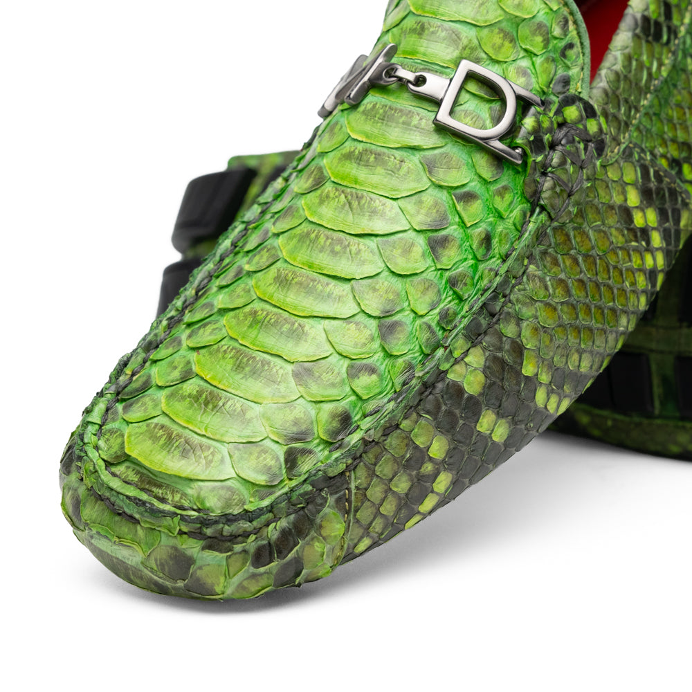 A pair of Marco Di Milano’s Pia Lemon Green driver shoes—crafted from green python skin with black soles and silver buckles—one upright and the other leaning gracefully, showcases the exquisite luxury of handcrafted men’s exotic footwear.