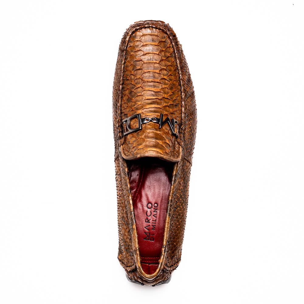 The Marco Di Milano Pia Cognac features brown python skin driver loafers with a metal buckle, visible black rubber soles, and one shoe upright while the other lies flat—a luxury men's shoe designed for style seekers.